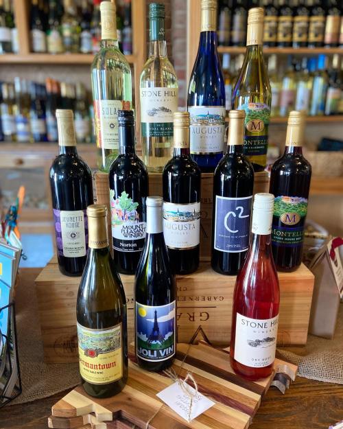 A display of various wine bottles arranged on wooden crates, showcasing different labels and colors.