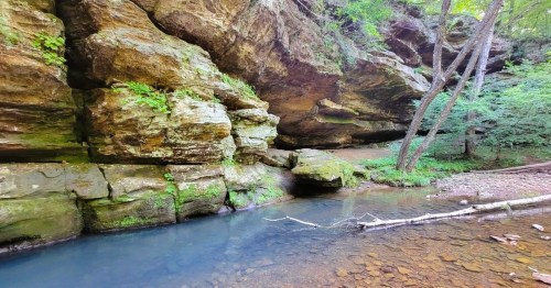 A serene swimming hole in Illinois, surrounder bby are boulders and unique rock formations.