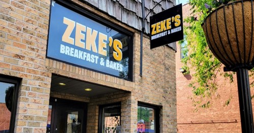 Exterior of Zeke's Breakfast & Bakes, featuring a brick facade and a sign with the restaurant's name.