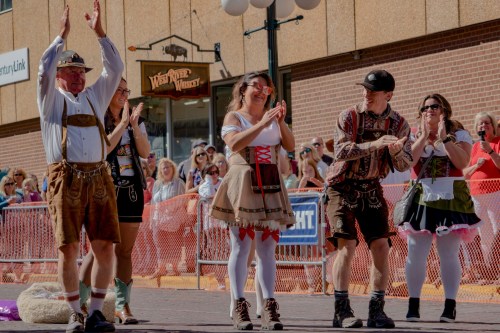A group of people in traditional attire clapping and celebrating at a lively outdoor event.