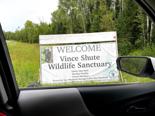 Sign for Vince Shute Wildlife Sanctuary, welcoming visitors and listing hours of operation.