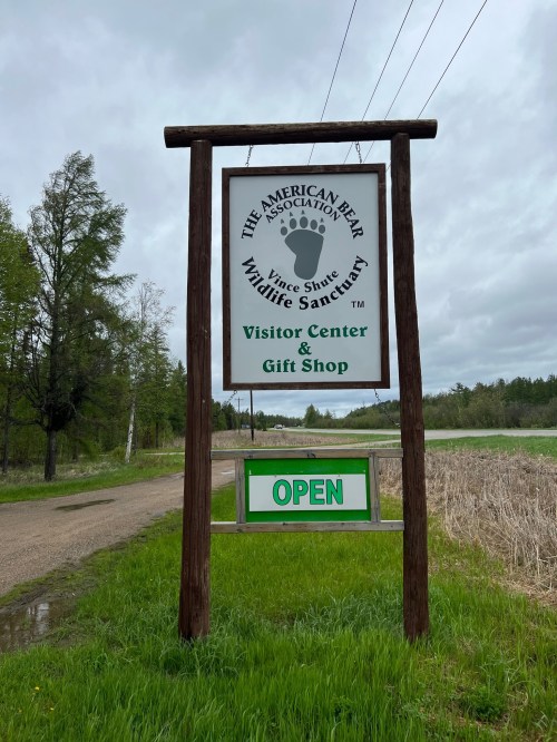 Sign for the American Bear Association Wildlife Sanctuary, featuring "Visitor Center & Gift Shop" and "OPEN" below.
