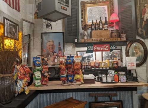 A vintage-style snack bar with chips, condiments, and decor, including an American flag and framed artwork.