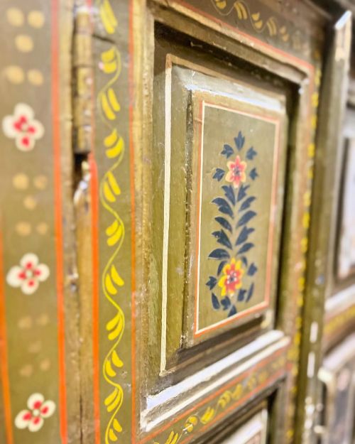 Close-up of a decorative wooden panel featuring floral designs and intricate patterns in earthy tones.