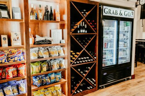 A wooden display with snacks and drinks, alongside a wine rack and a refrigerated "Grab & Go" section.