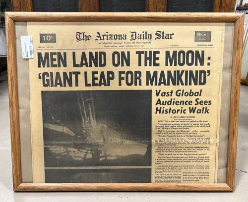 Framed newspaper headline: "Men Land on the Moon: 'Giant Leap for Mankind'" with a photo of the moon landing.