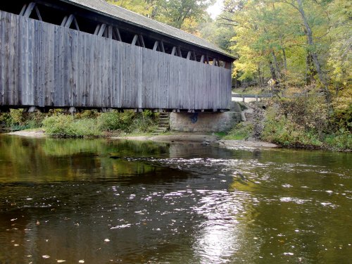 Looking at the side of a covered bridge as it crosses over a river in Michigan.