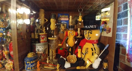 A display case filled with various Planters Peanut memorabilia, featuring Mr. Peanut figures and peanut-themed items.