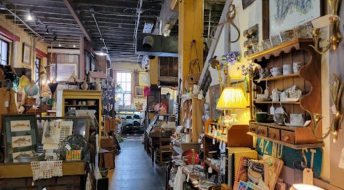 A cozy antique shop filled with vintage items, furniture, and decor, creating a warm and inviting atmosphere.