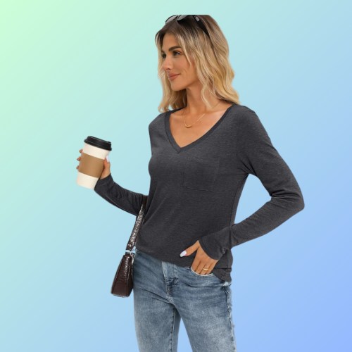 A woman in a gray long-sleeve top holds a coffee cup, smiling against a gradient background.