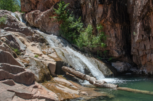 view of a waterfall down a sloping rock into a pool below at water wheel falls in arizona