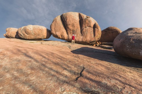 Human standing next to large rocks at state park