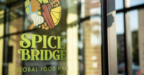 Close-up of the Spice Bridge sign featuring colorful food illustrations and the text "Global Food Hall."
