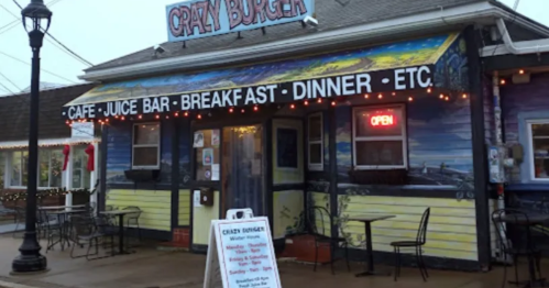 Colorful exterior of Crazy Burger restaurant with outdoor seating, open sign, and menu board in front.