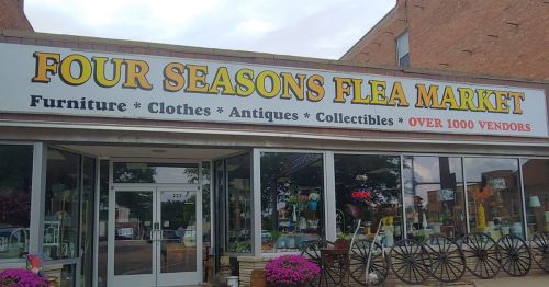 Sign for Four Seasons Flea Market, featuring furniture, clothes, antiques, and collectibles, with over 1000 vendors.