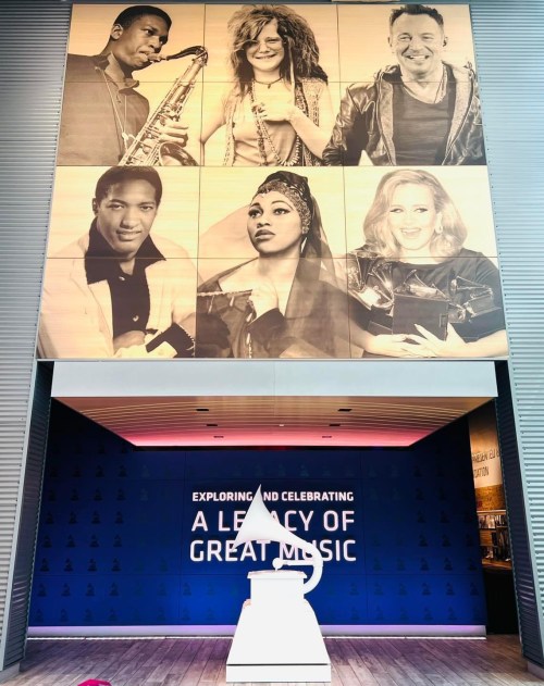 A wall display featuring iconic musicians above a sign that reads "Exploring and Celebrating a Legacy of Great Music."