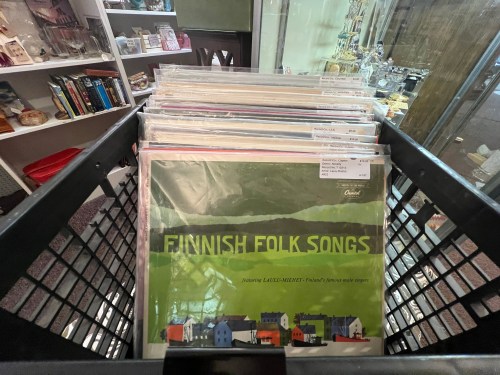 A black basket filled with vinyl records, prominently featuring "Finnish Folk Songs" on the top cover.