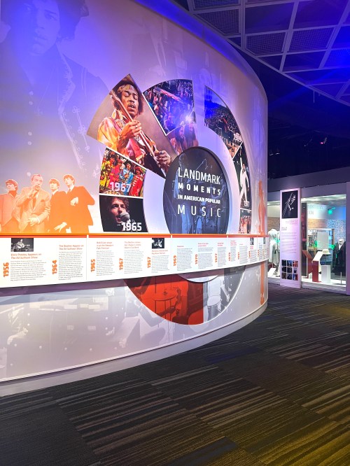 Exhibit display featuring a timeline of landmark moments in American popular music, with images and text panels.
