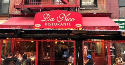 Red awning and sign of Da Nico Ristorante, with outdoor seating and diners visible in a bustling urban setting.