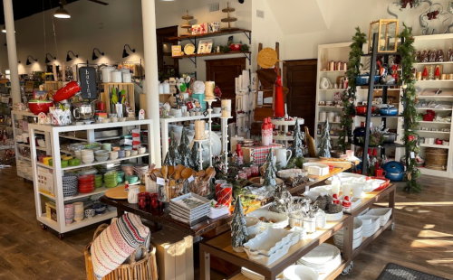 A cozy store filled with kitchenware, holiday decor, and festive table settings, showcasing various colorful items.