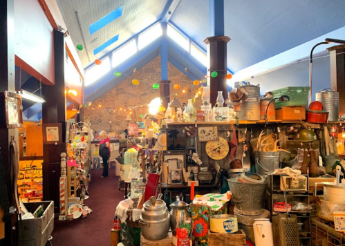 A vibrant antique shop filled with various vintage items, colorful decor, and warm lighting.