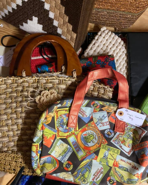 A collection of various handbags, including woven and patterned styles, displayed together on a surface.
