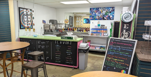 A colorful ice cream shop interior with a service counter, flavor menu, and seating area.