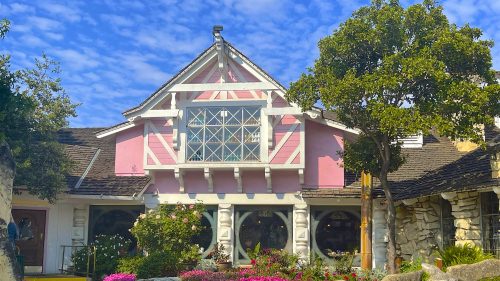 Exterior of the Madonna Inn in California, with bright pink exterior on a historic Victorian building