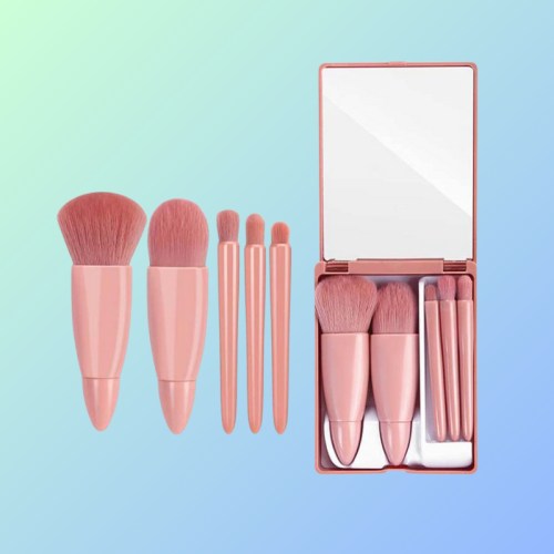 Set of pink makeup brushes and a compact mirror on a gradient background.