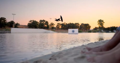 Wakeboarder catches big air off a ramp at sunset on the lake at Velocity Island Park
