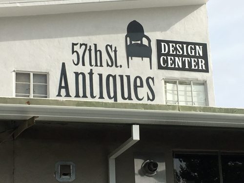 Sign on a building featuring "57th St. Antiques" and "Design Center" in bold lettering.