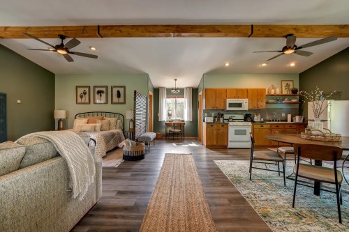 Cozy open-concept living space with a kitchen, dining area, and comfortable seating, featuring warm colors and natural light.