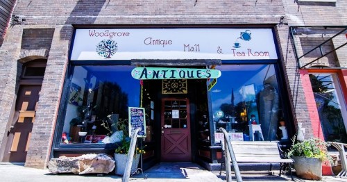 A charming antique shop with a sign reading "Woodgrove Antique Mall & Tea Room," featuring a welcoming entrance.
