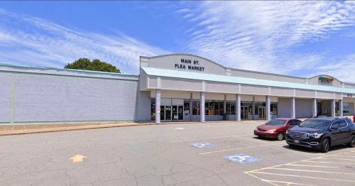 Exterior view of Main St. Flea Market with a parking lot and blue sky in the background.