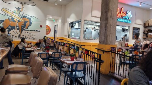 A vibrant restaurant interior with colorful decor, seating areas, and a mural of a cowboy on a horse.