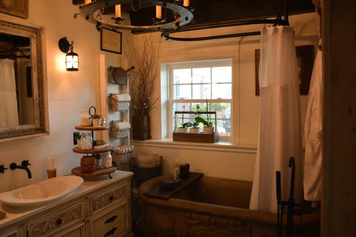 Cozy bathroom featuring a vintage tub, wooden accents, and natural light from a window with plants.