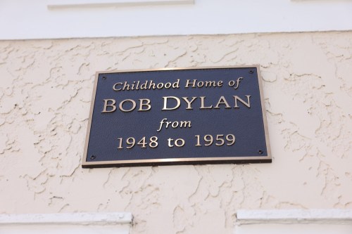 Plaque on a wall marking the childhood home of Bob Dylan, noting his residence from 1948 to 1959.