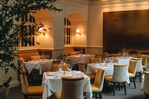 Elegant restaurant interior with neatly set tables, soft lighting, and cozy seating arrangements.