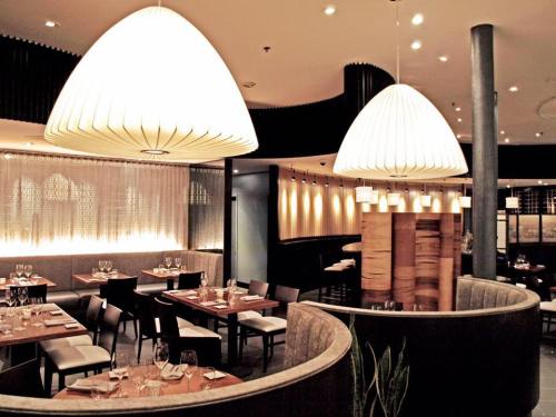 Modern restaurant interior featuring elegant lighting, wooden accents, and cozy seating arrangements.
