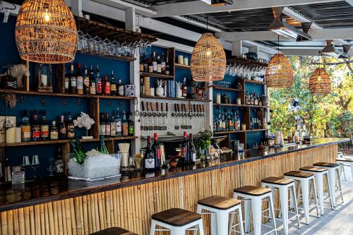 A stylish bar with bamboo decor, hanging lights, and a variety of bottles displayed on shelves.