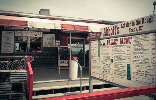 Exterior of Abbott's Lobster in the Rough in Noank, CT, featuring a menu board and ordering area.