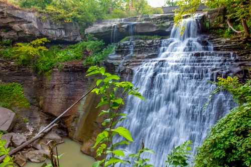 Brandywine Falls cascading over rocks in late summer, surrounded by greenery in Cuyahoga Valley National Park.
