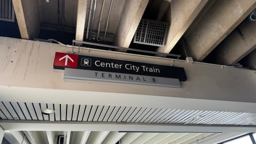 Sign for Center City Train, indicating Terminal B, mounted on a ceiling with an arrow pointing upwards.