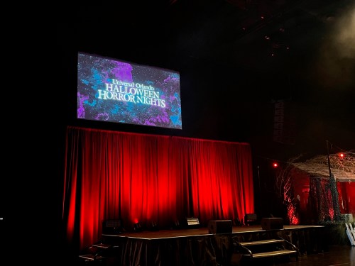 Stage setup for Universal Orlando's Halloween Horror Nights, featuring a colorful screen and red curtains.