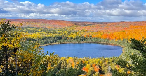 Vibrant fall colors ring the blue waters of a Northwoods lake.