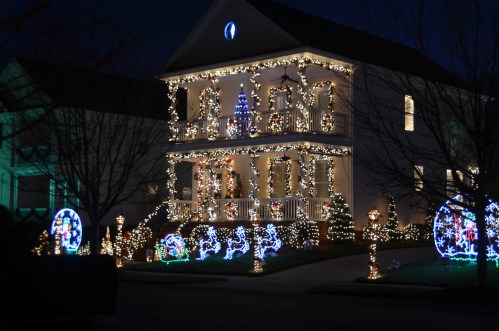A beautifully decorated house with festive lights and holiday decorations, glowing in the night.