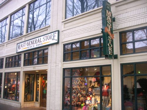Exterior of Mast General Store, featuring a festive window display with a Christmas tree and holiday decorations.