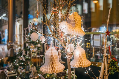 A decorated tree with paper bells and ornaments, illuminated by soft lights, creating a festive atmosphere.