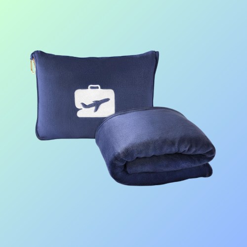 A navy travel blanket and matching pouch with a suitcase and airplane design on a gradient background.