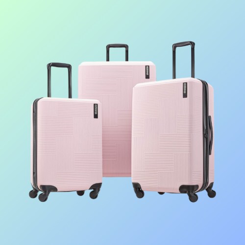 Three pink suitcases of varying sizes on a gradient blue-green background.